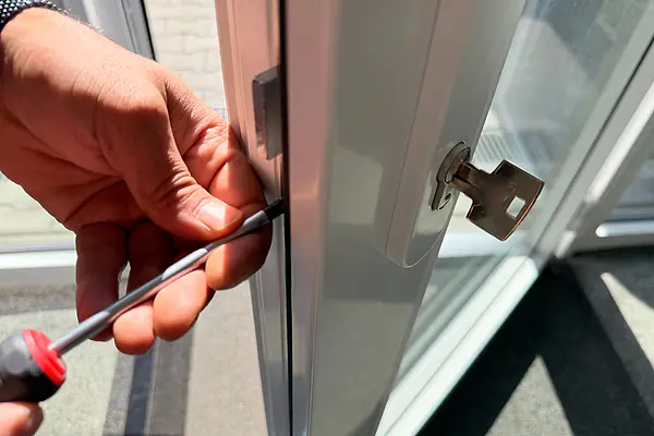 Monteur von Openmydoor24 arbeitet mit dem Schraubendreher am Schließzylinder einer Glastür